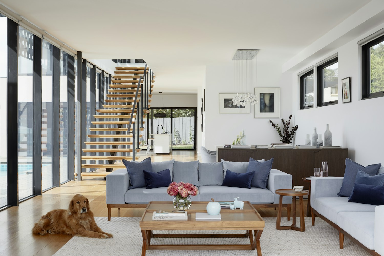 Contemporary living room with a warm wood staircase